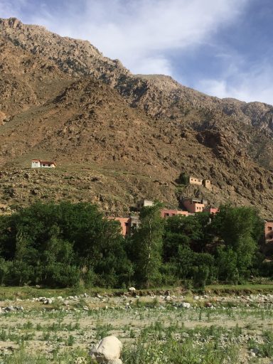 Mountainous landscape with terraced buildings and lush greenery at the base.